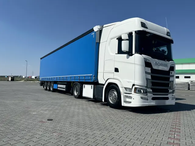 Zestaw z niebieską plandeką na parkingu przy autostradzie